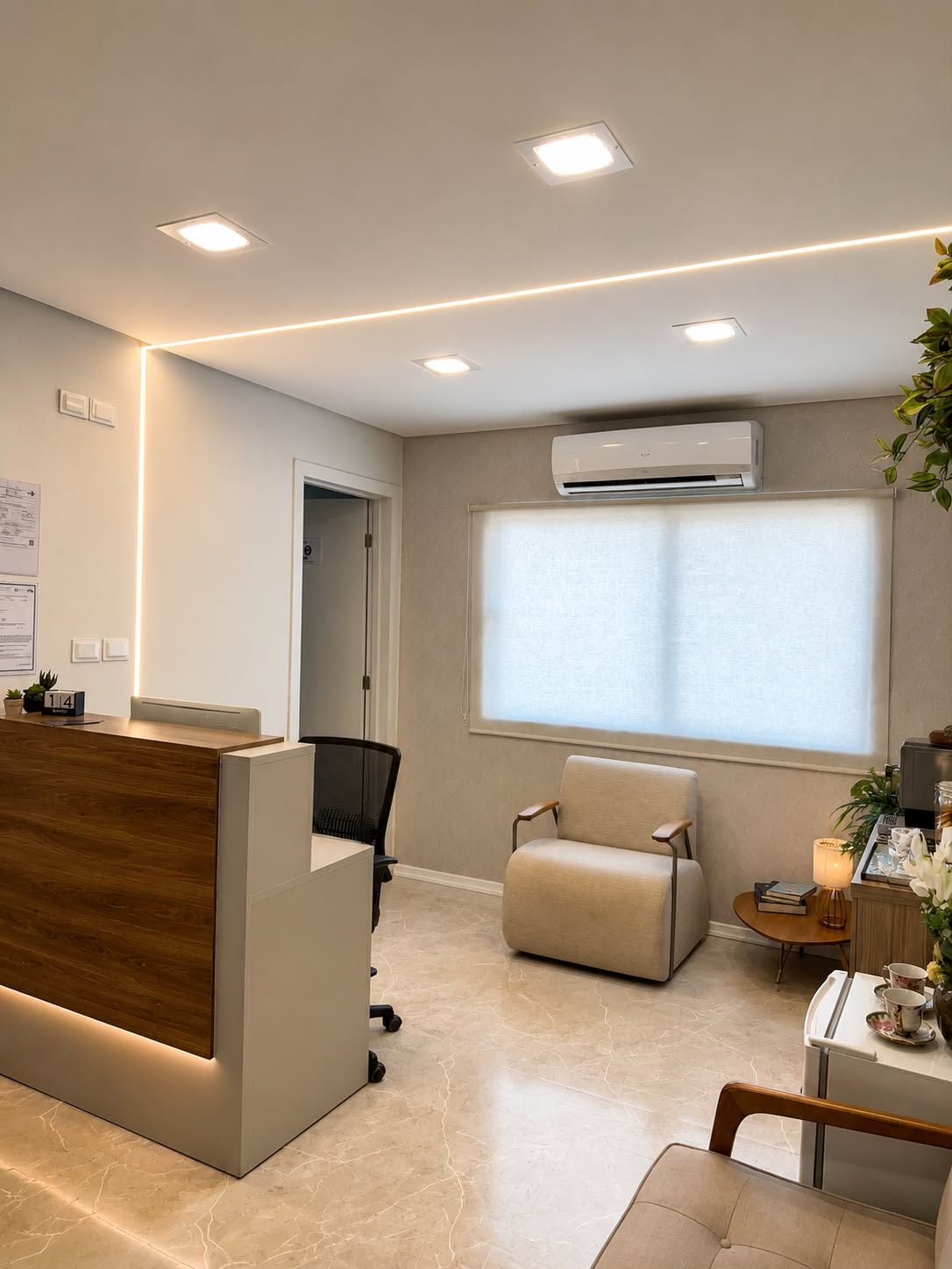 Recepção da Vertebral Care, com balcão de madeira, poltrona e iluminação acolhedora.
